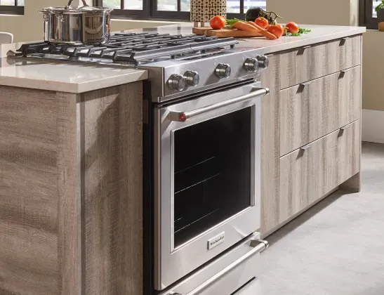 KitchenAid stainless steel range installed in a white kitchen island to maximize open-concept workflow and design.
